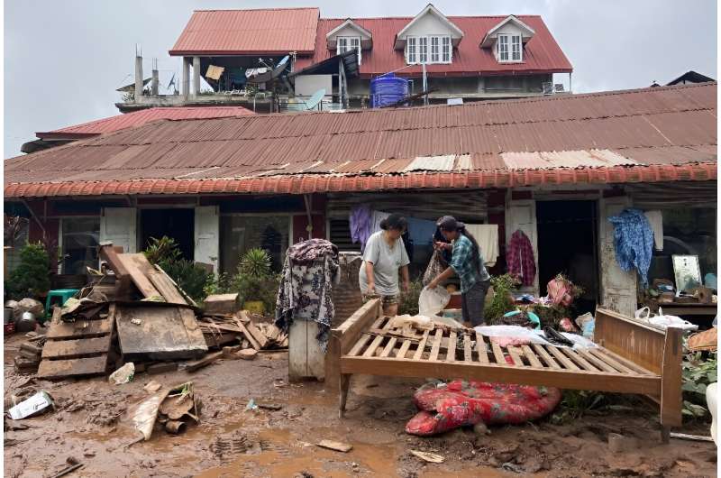 People clean up after heavy flooding in Kalaw township in southern Myanmar's Shan state on September 19, 2024, following heavy rain caused by typhoon Yagi.