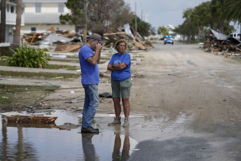 Leslie Sturmer (right), a University of Florida employee, and John Rittenhouse, general manager of the Cedar Key Water and Sewer District, both residents of Cedar Key, Fla., speak after Hurricane Helene on Friday, Sept. 27, 2024. (Gerald Herbert/AP)